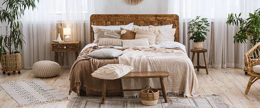 A bedroom with a neutral palette, layered blankets and cosy decor: the perfect place to get a good night's sleep.