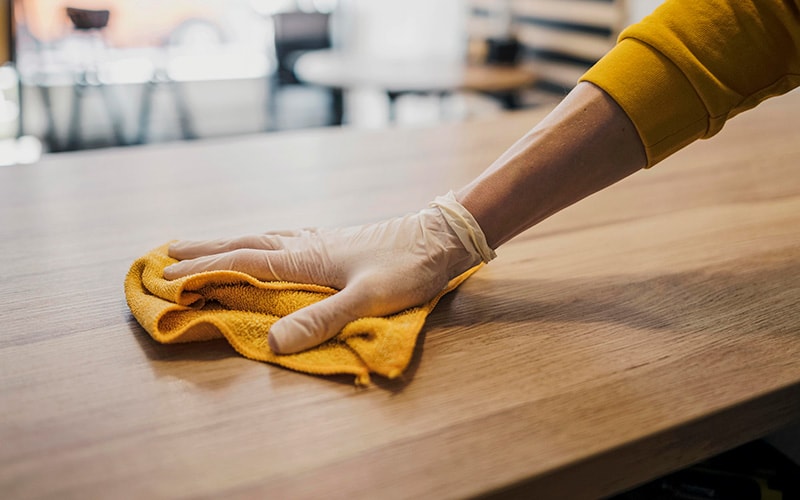 Dry wiping the coffee table with a microfiber cloth
