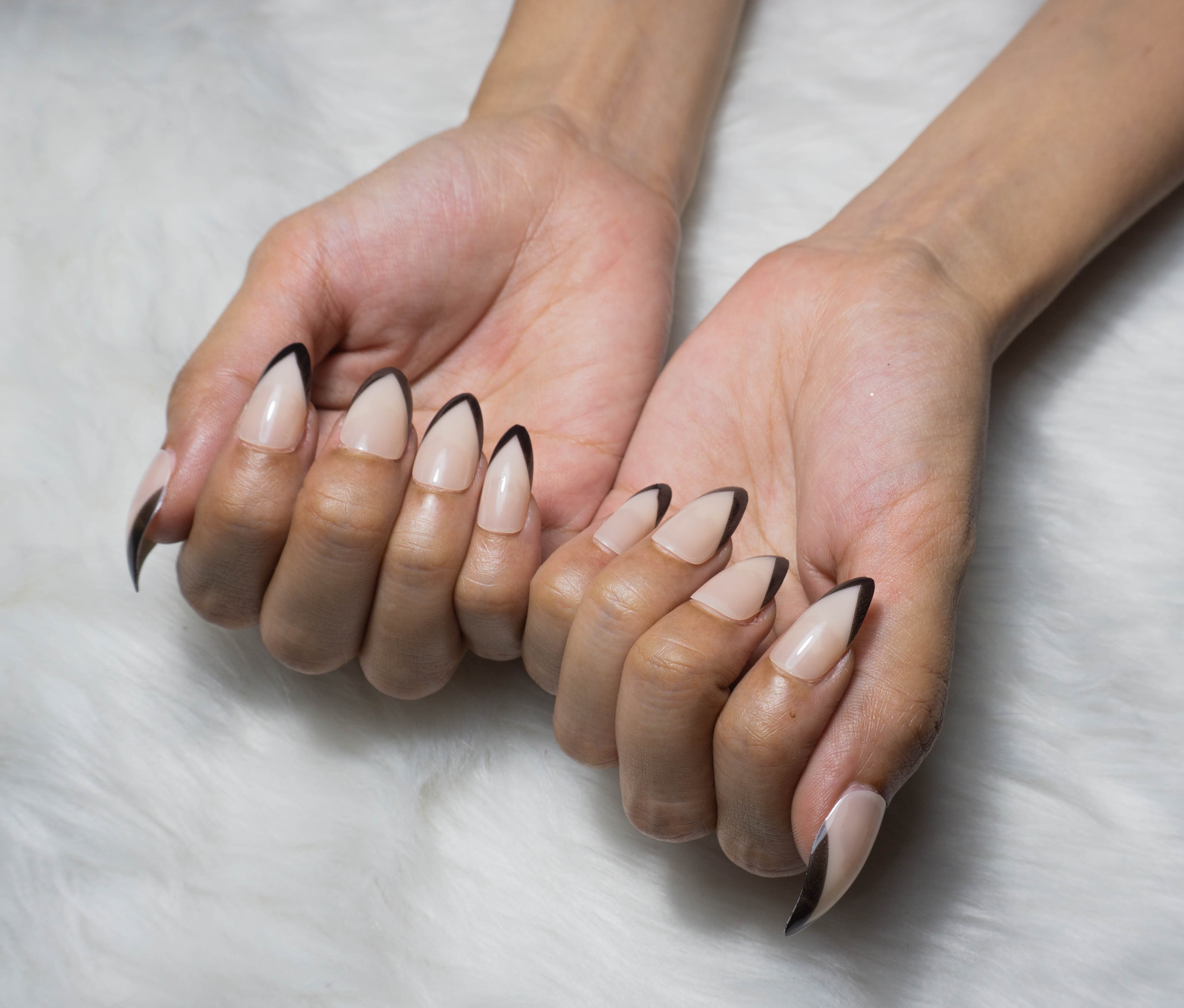 A black french tip manicure with proper application techniques