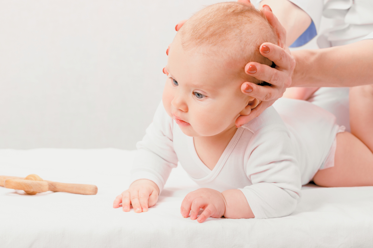 Baby doing tummy time while holding up head. Poppyseed Play