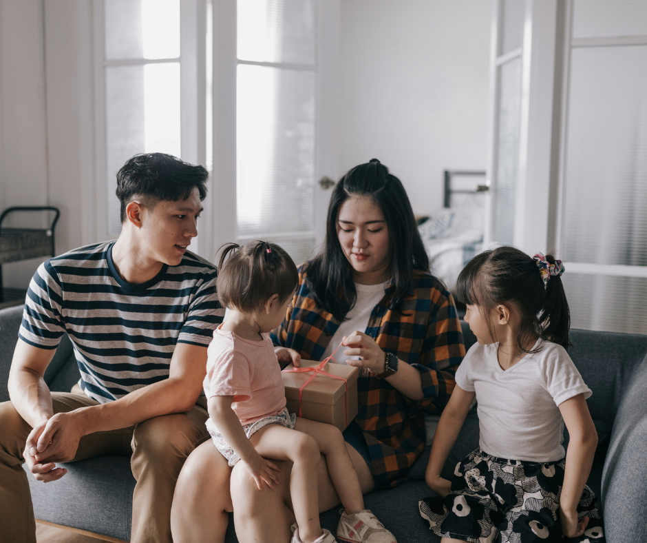 a family opening a gift together; everyone is wearing a t shirt