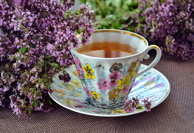 An image of a cup of herbal tea surrounded by lilacs.