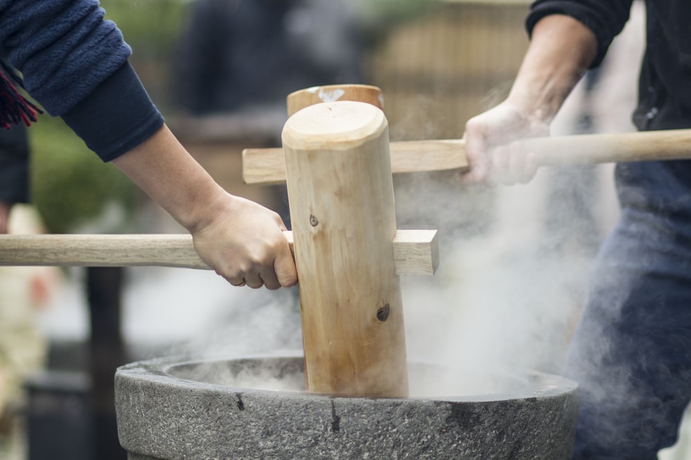 Using wooden hammer to make mochi