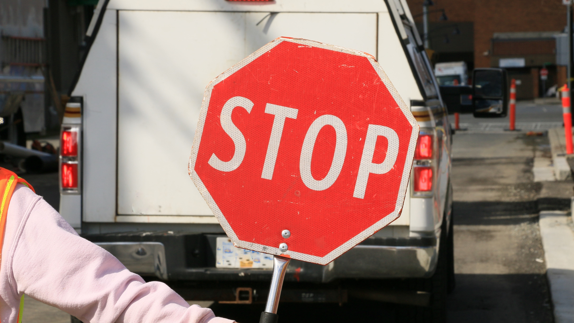 Hand holding stop sign out in front of the camera