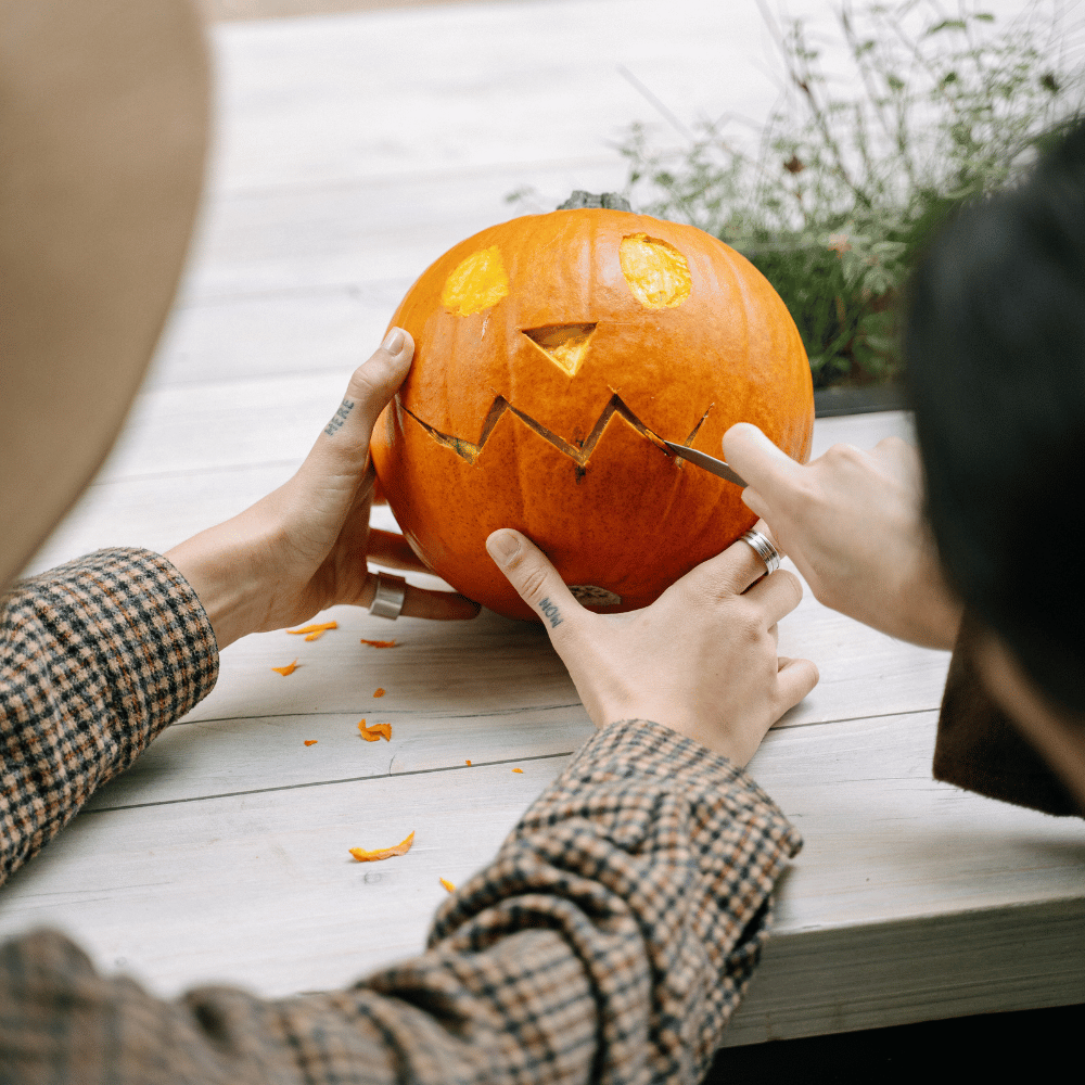 A person carving a pumpkin with a carving knife