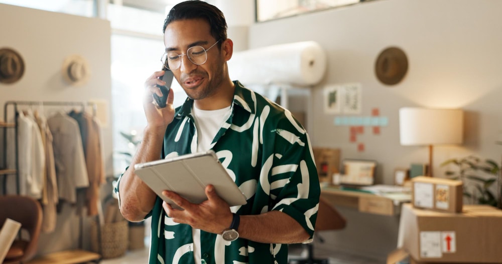 A seamless communication phone call and a man with a tablet using cloud solutions.