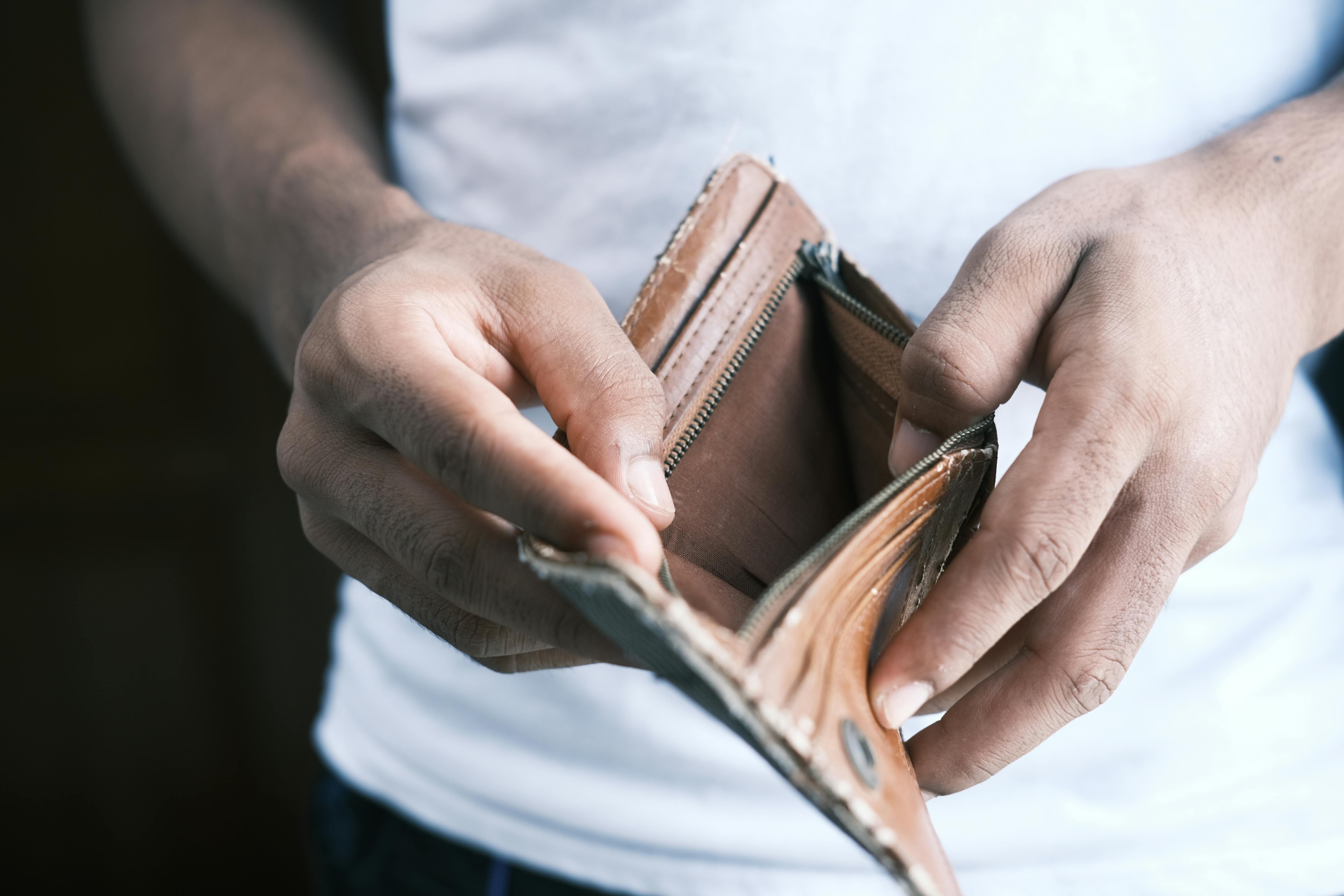 Homeowner holds empty wallet signaling bankruptcy.