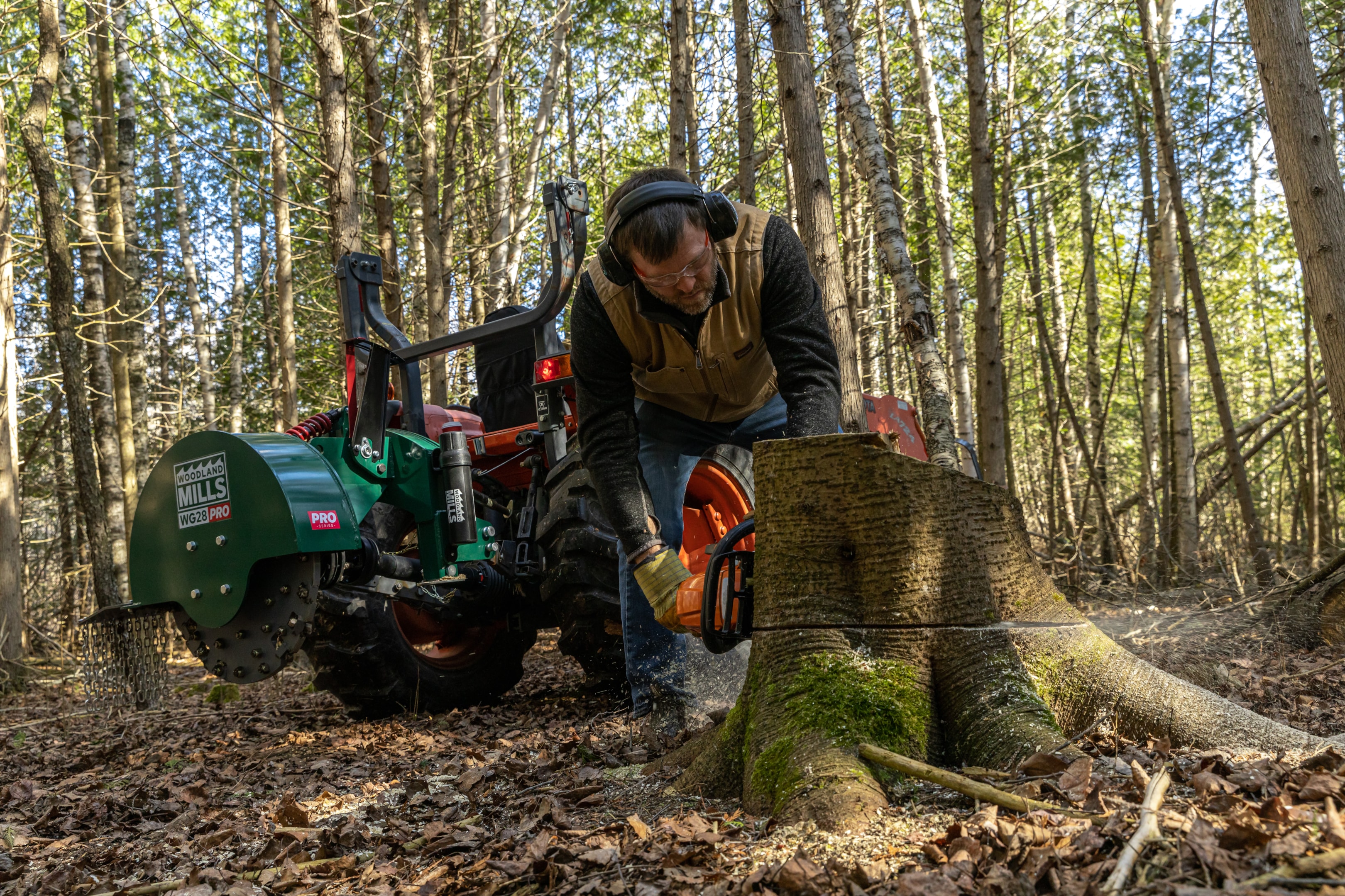 A land owner cutting a tree stump preparing to use his Woodland Mills WG28 PRO Stump Grinder. 