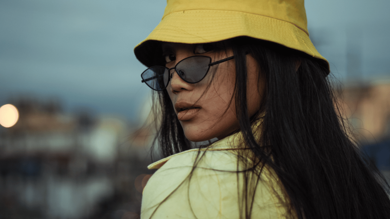 woman wearing a yellow bucket hat and sunglasses