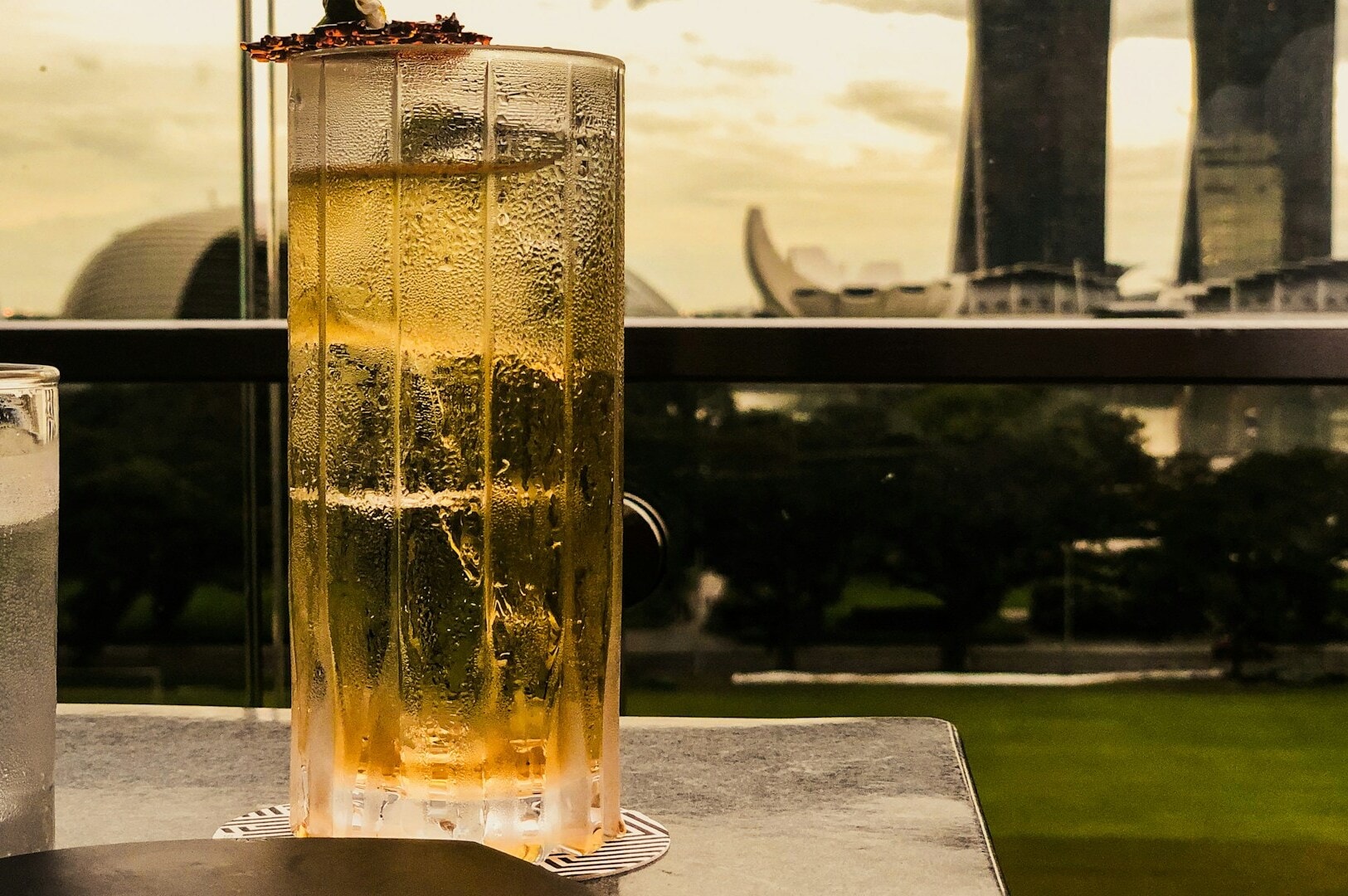 A clear glass filled with a deep yelow beverage, resting on a wooden table in an inviting atmosphere.