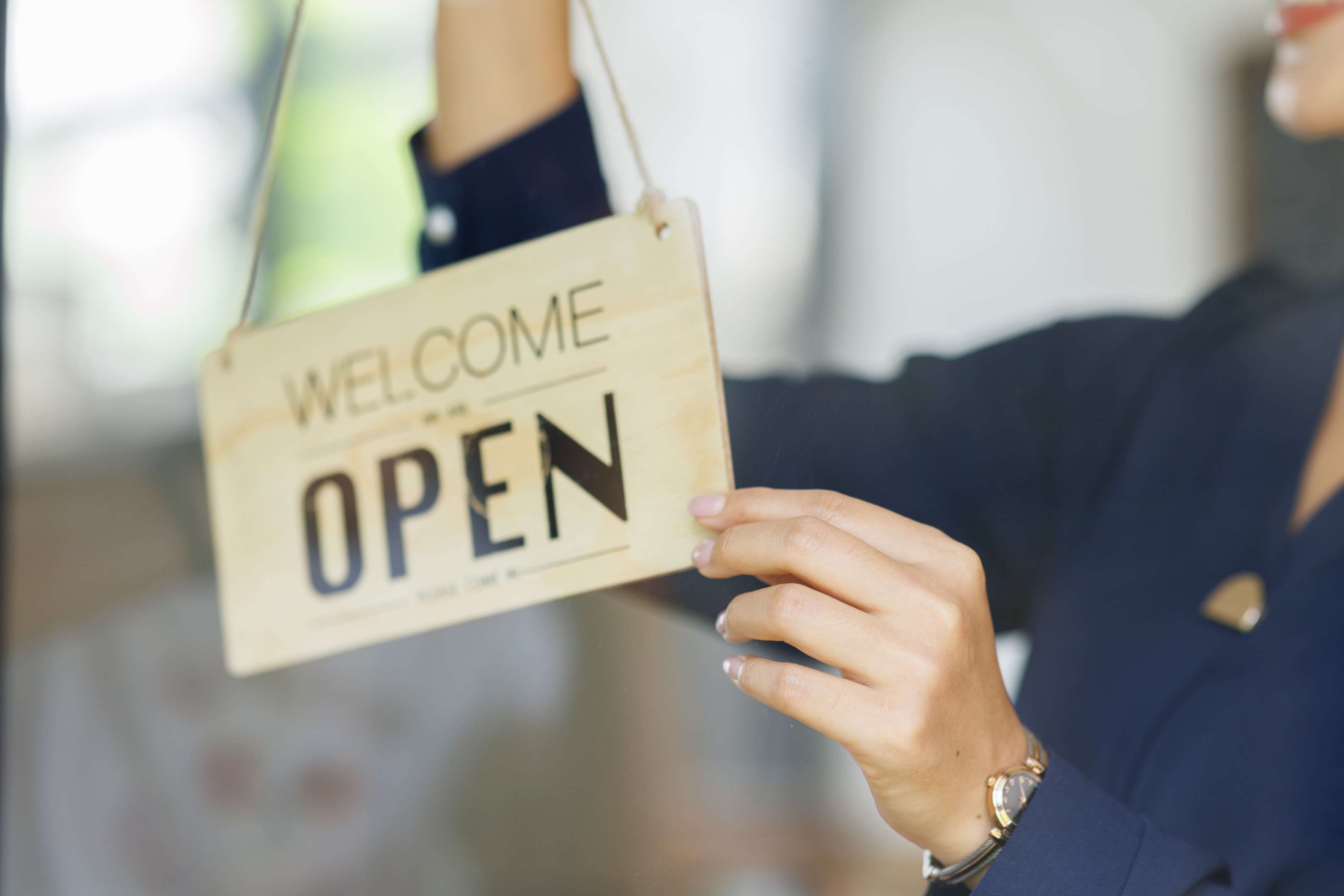 A small business owner flips the open sign