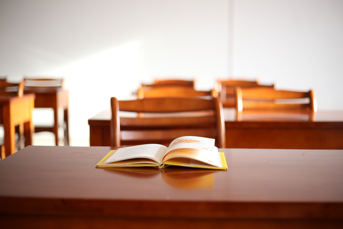 Open textbook on a desk in an empty Philippine classroom