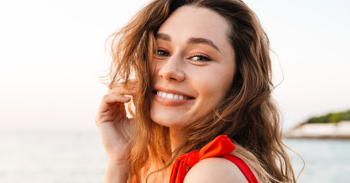 Smiling woman in a red top, representing confidence during OnlyFans seasonal tax period.