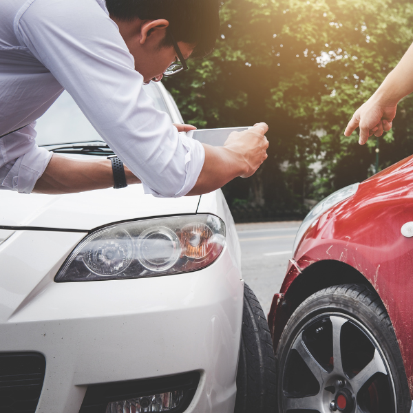 Image of a person taking pictures to include in a car accident injury claim.
