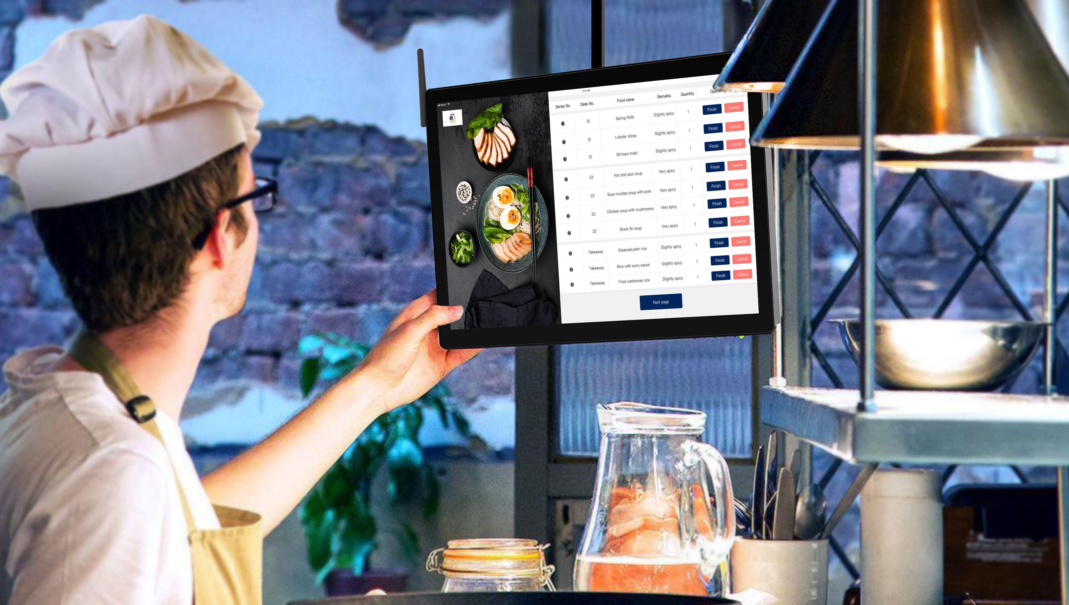 In a bustling restaurant setting, staff members are actively preparing food while a phone rests on the counter nearby, highlighting the integration of technology in restaurant operations. This scene reflects the importance of efficient food preparation and customer interactions in enhancing the overall dining experience.