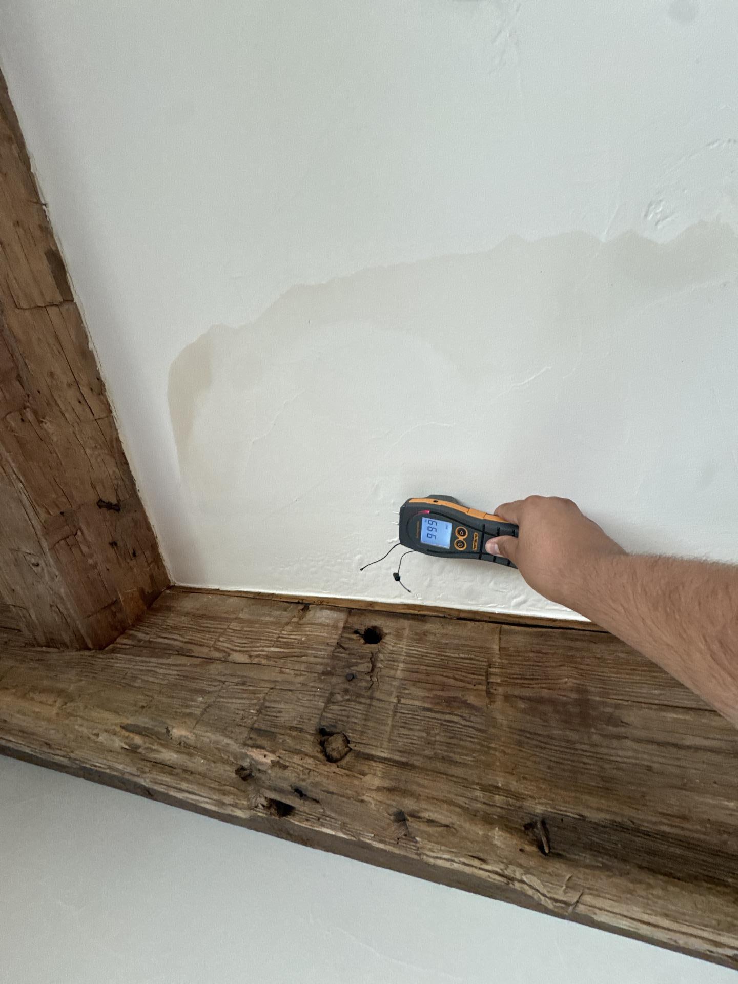 A worker is inspecting the ceiling drywall near an air conditioning vent, assessing for signs of water damage and potential mold growth. This inspection is part of the water damage restoration process, which aims to prevent further damage and ensure the affected areas are restored to their pre-loss condition.