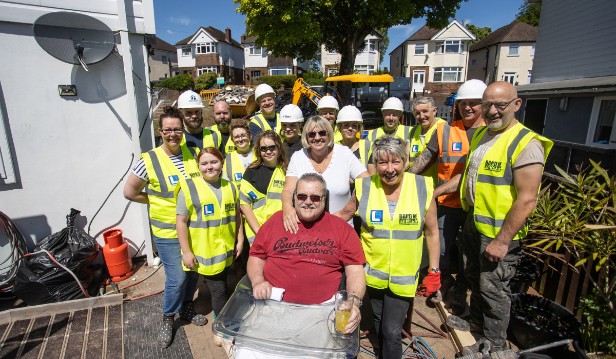 Band of Builders - group shot of volunteer workers and the recipients on a building project