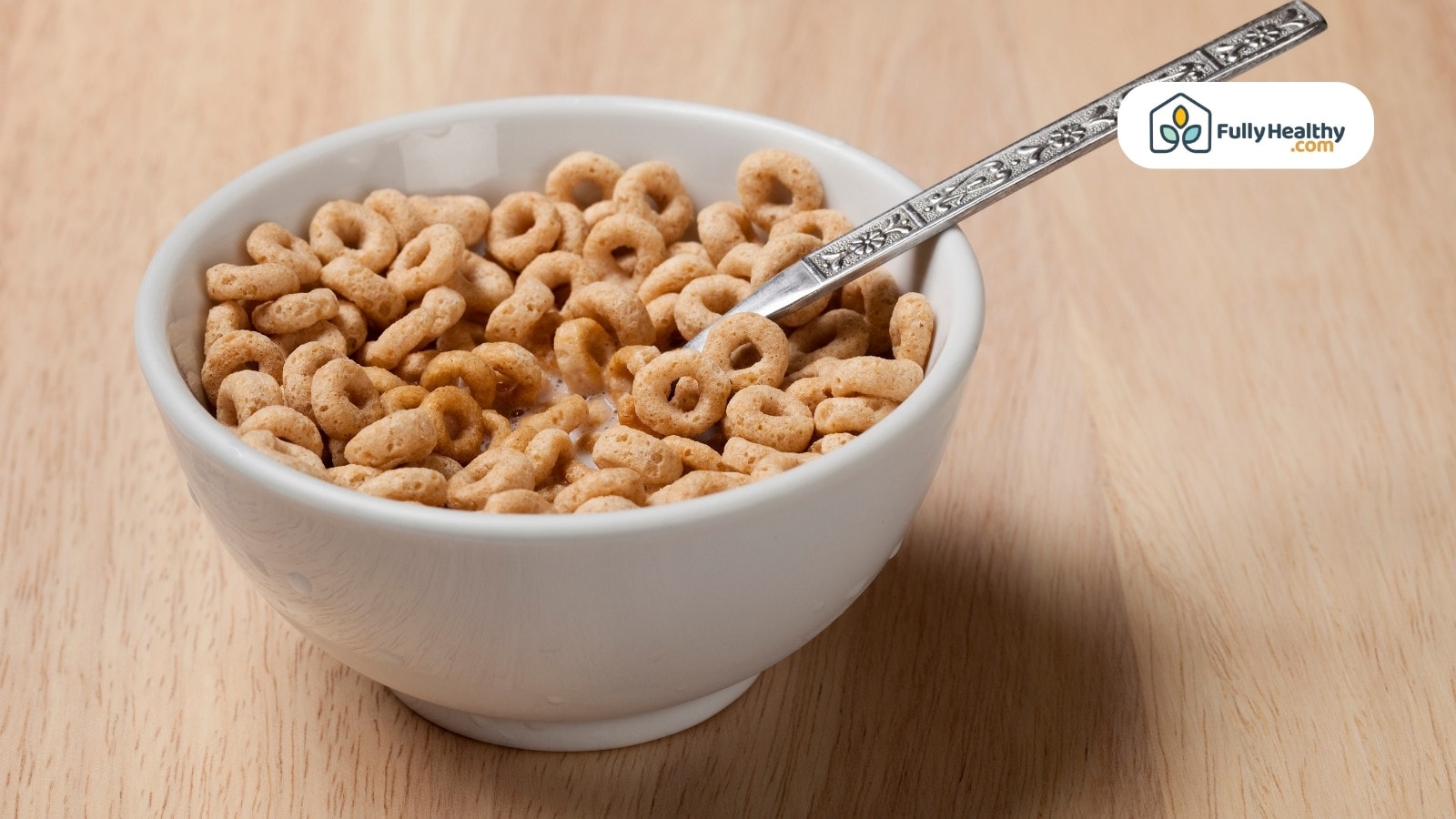 Plain cereal loops with milk in white bowl and spoon