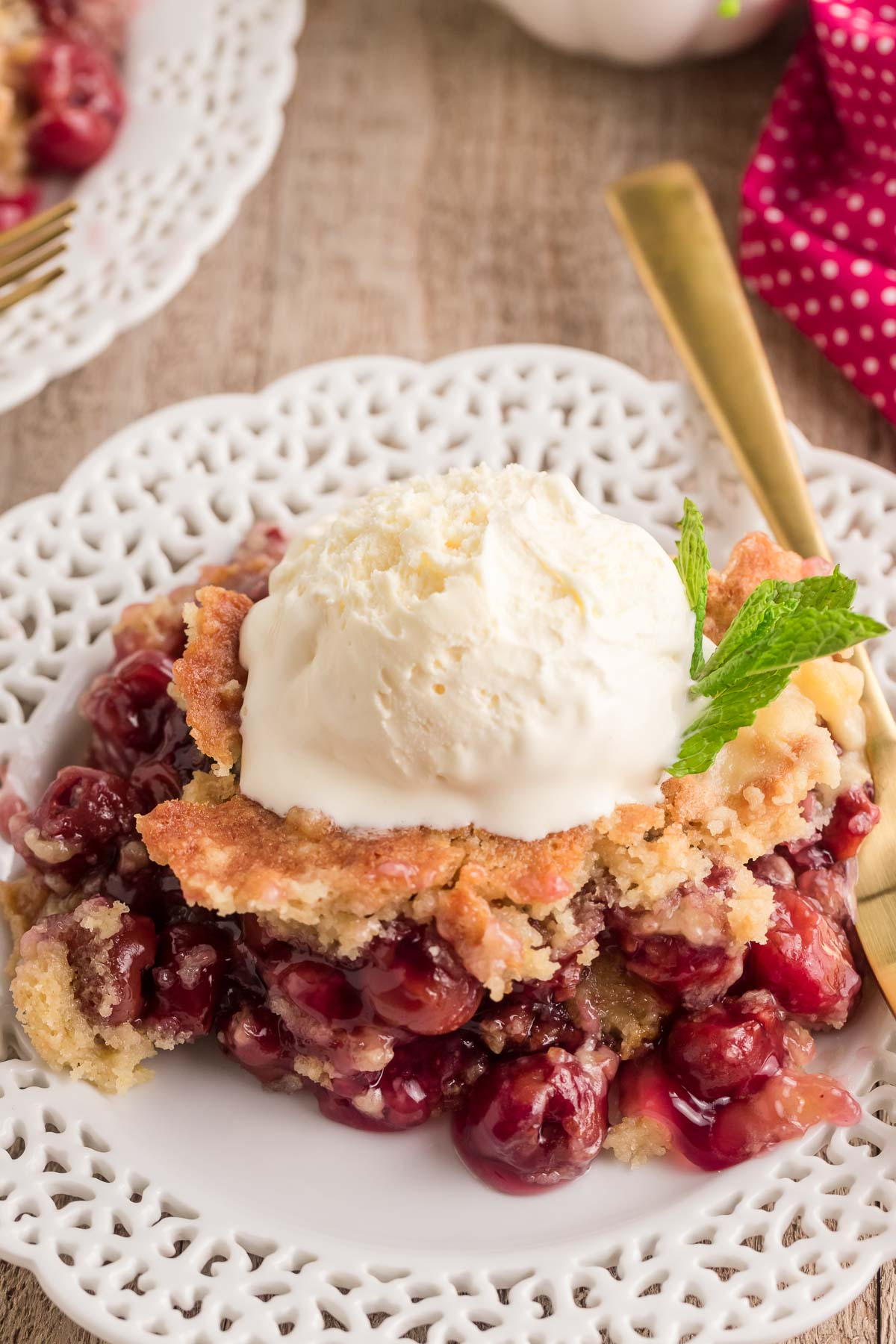 cherry dump cake on a plate topped with ice cream