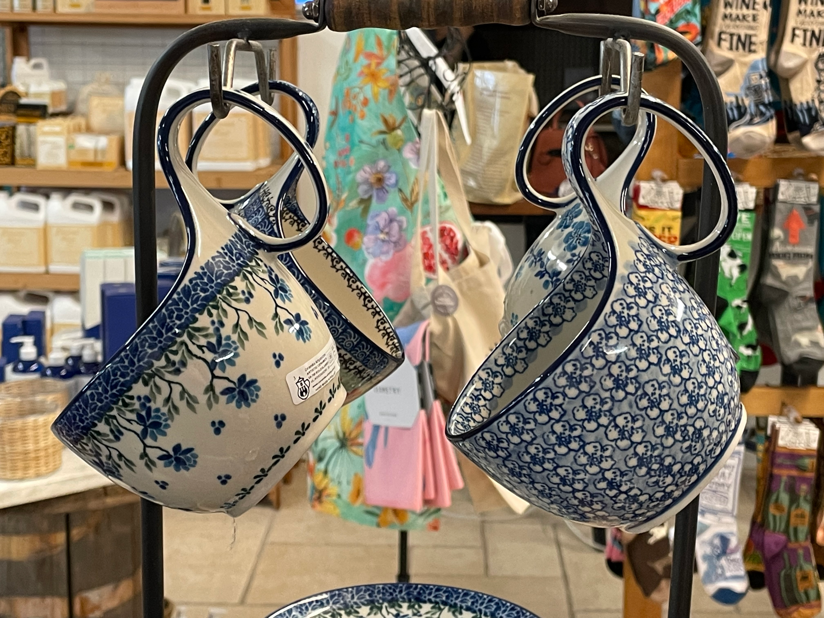 Two Hand painted Polish Pottery Mugs on a mug rack.