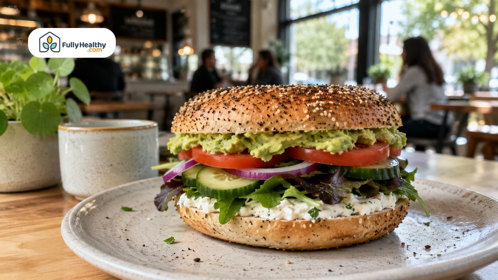 Vegan bagel sandwich with avocado, tomato, cucumber, greens, and dairy-free spread