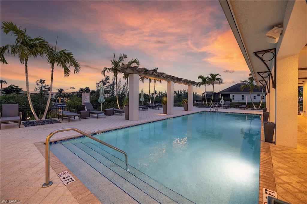 The image depicts a serene marina in the Hidden Harbor neighborhood of Fort Myers, Florida, featuring private boat docks and various watercraft lining the canal. The lush landscaping and tranquil environment suggest a resort-style lifestyle, ideal for residents seeking easy access to the Gulf and recreational facilities.
