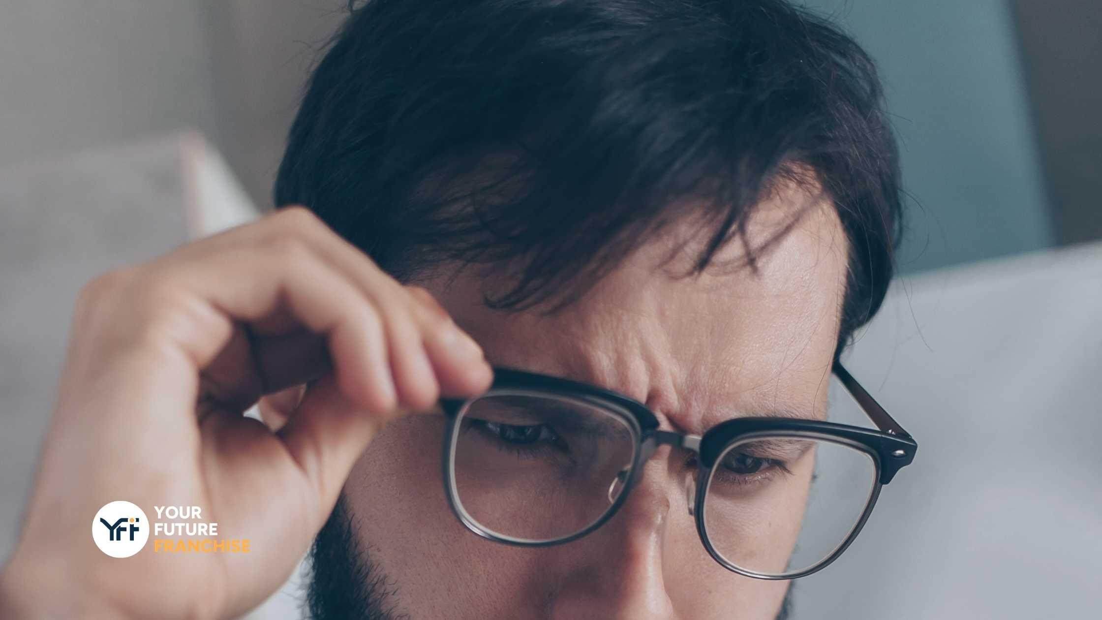 A man with glasses reading something intensely