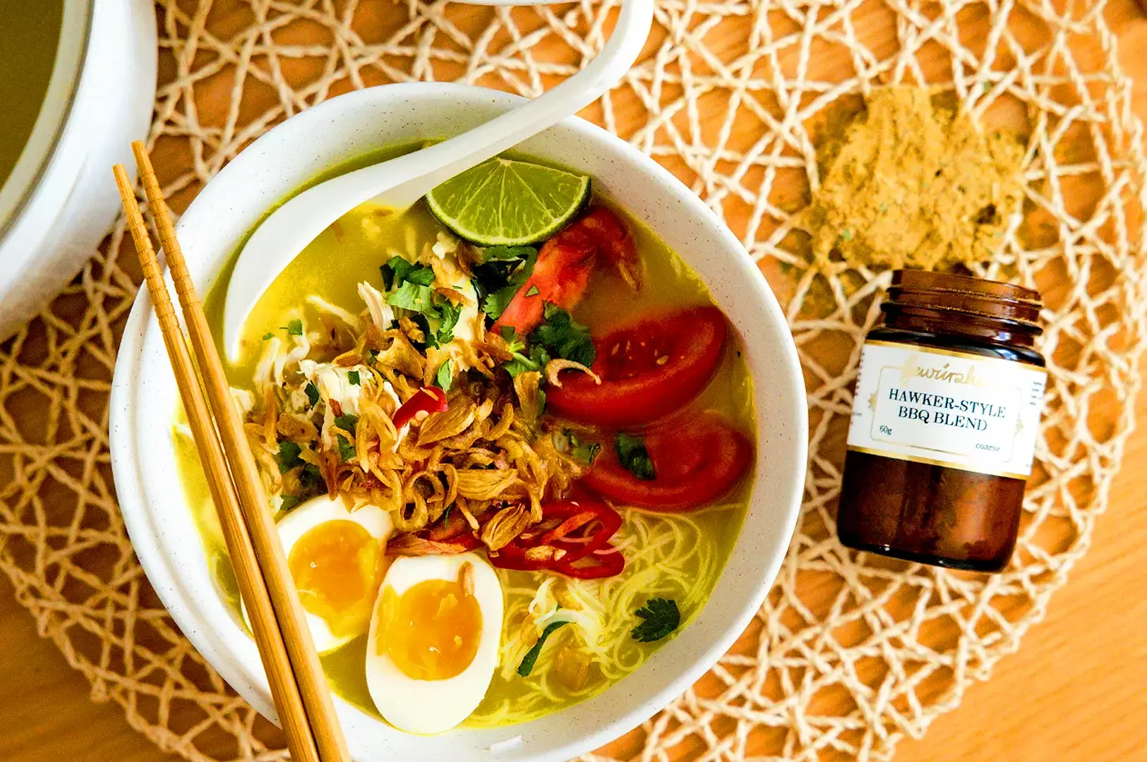 Indonesian noodle soup with boiled eggs, crispy shallots, tomatoes, lime and fresh herbs