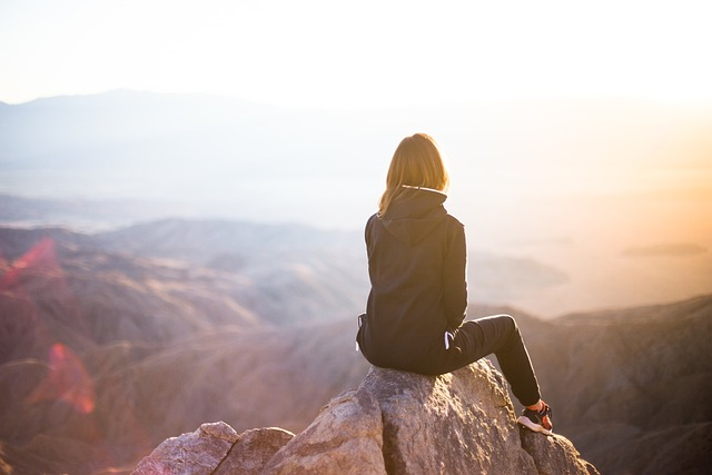 a woman sitting on top of a rock