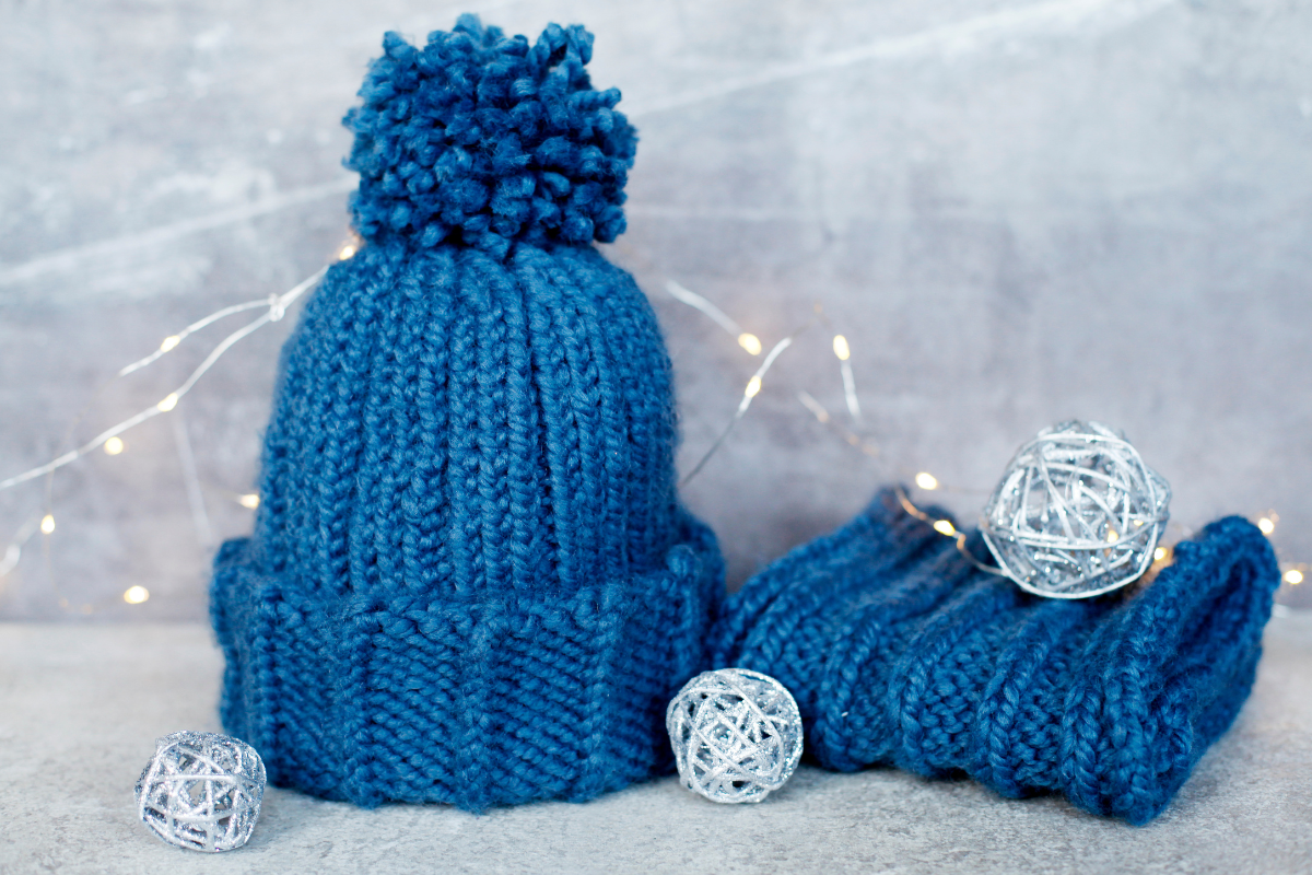 Crocheted winter accessories displayed on a cozy blanket, perfect for cold weather.