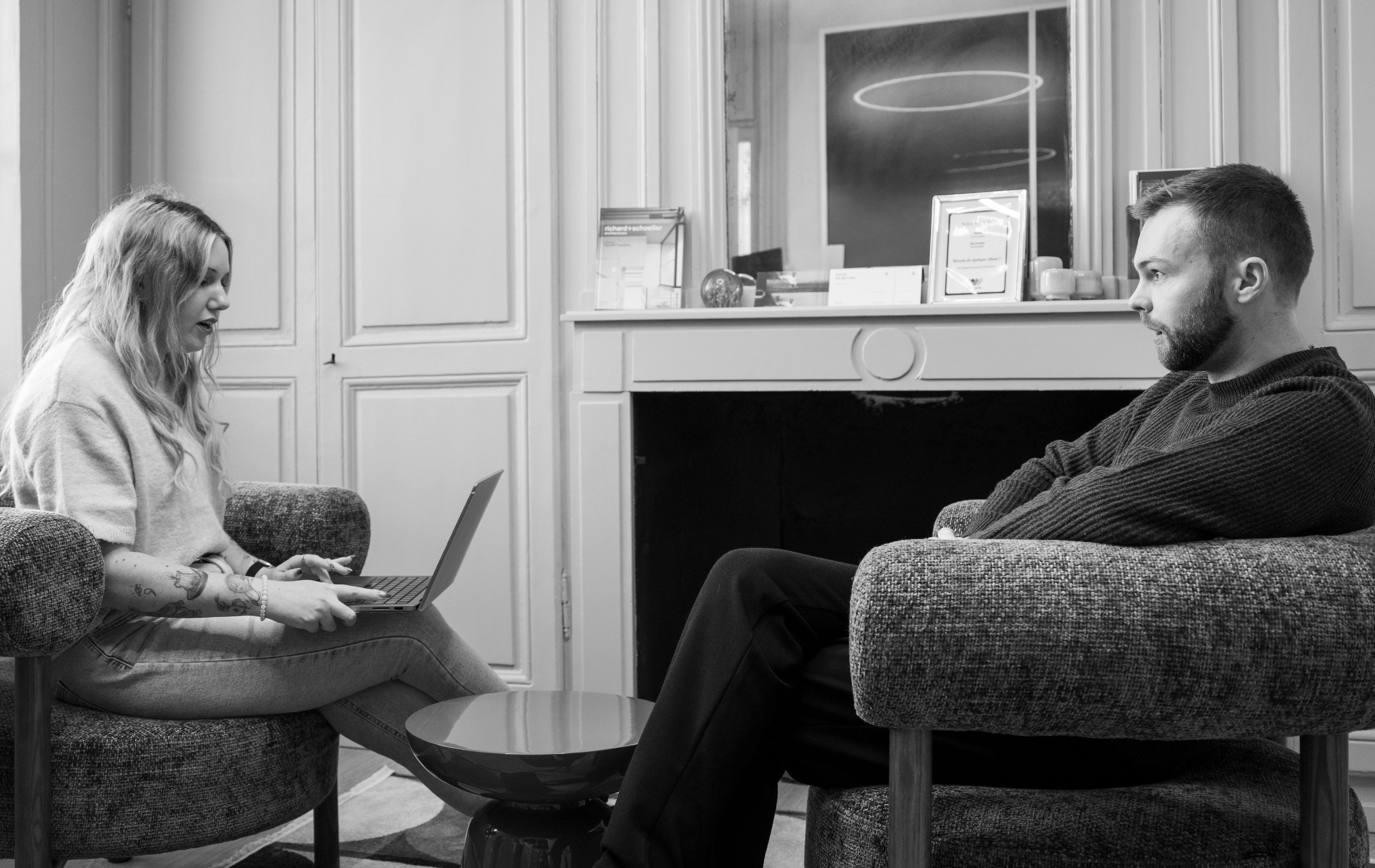 Deux personnes collaborent sur un ordinateur portable pour optimiser un contenu SEO.