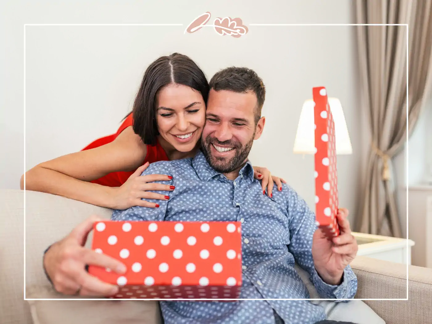 Couple smiling and holding a red polka dot gift box - fabulous flowers and gifts