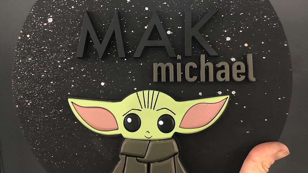 custom sign with cute green cartoon and a name on a round black wooden base by Jazzlyn Vincent 