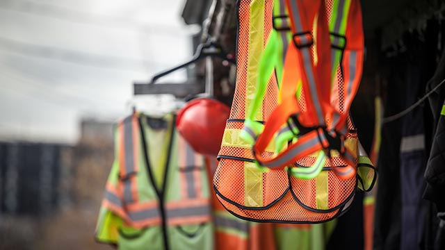 PPE equipment including vest, harness, hard hat.