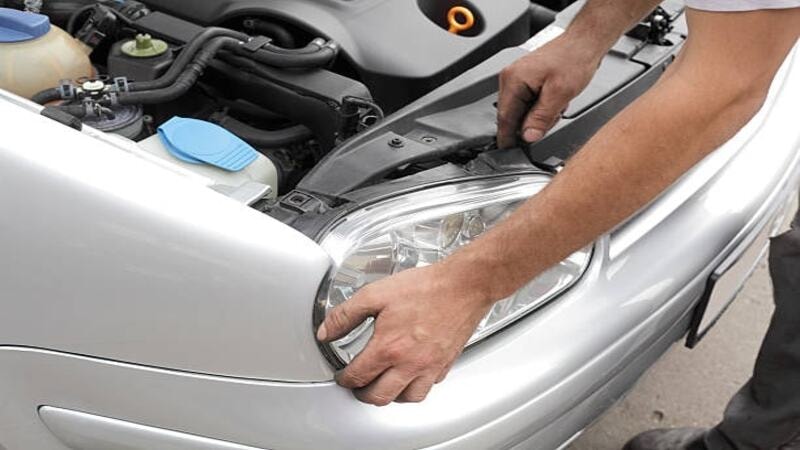 An expert placing the headlight after repairing.
