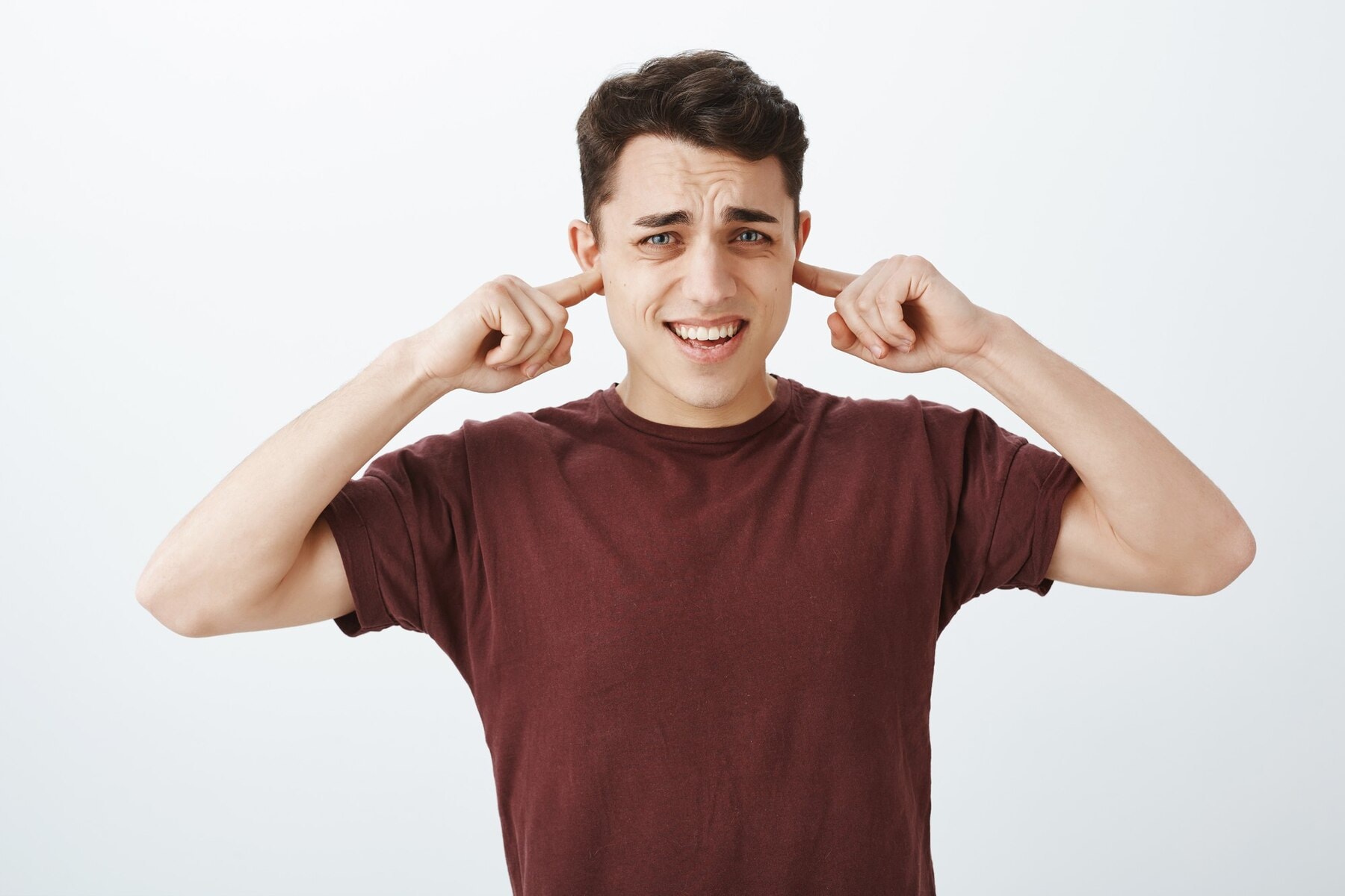 Young man covering his ears