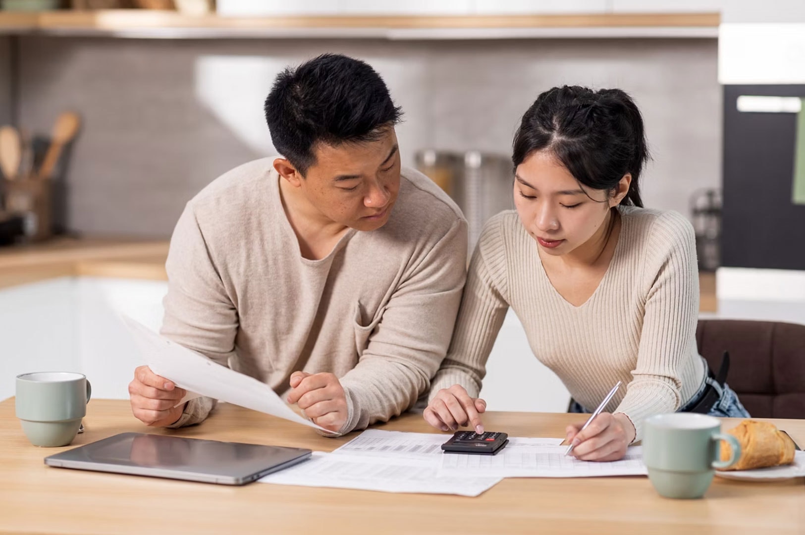Couple calculating household expenses and budgeting.