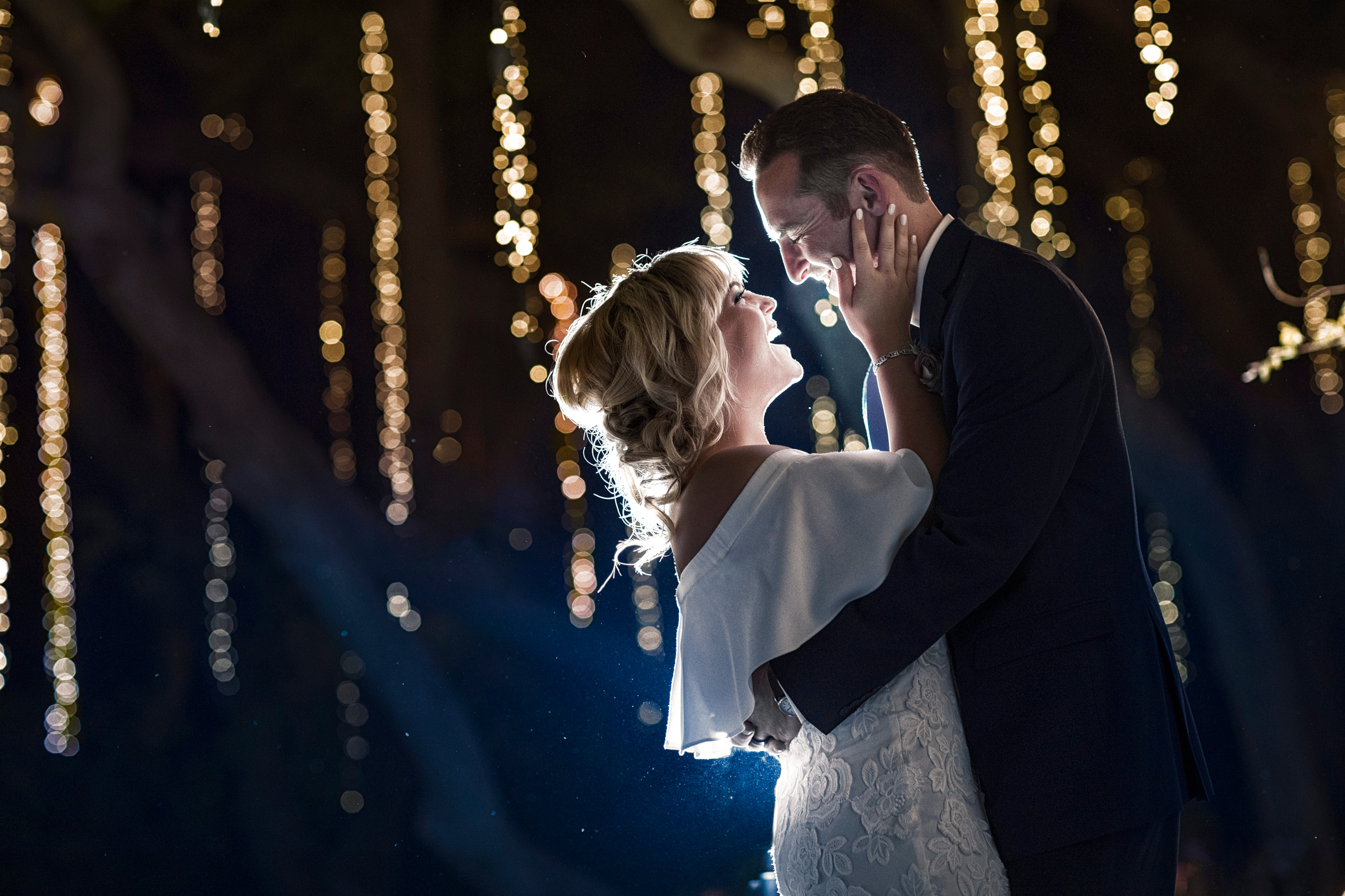 A wedding photographer capturing a loving moment between a couple