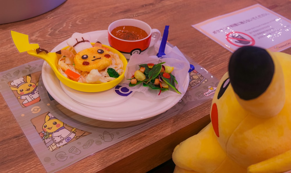 Pikachu plushie sitting in front of a Pikachu-themed meal