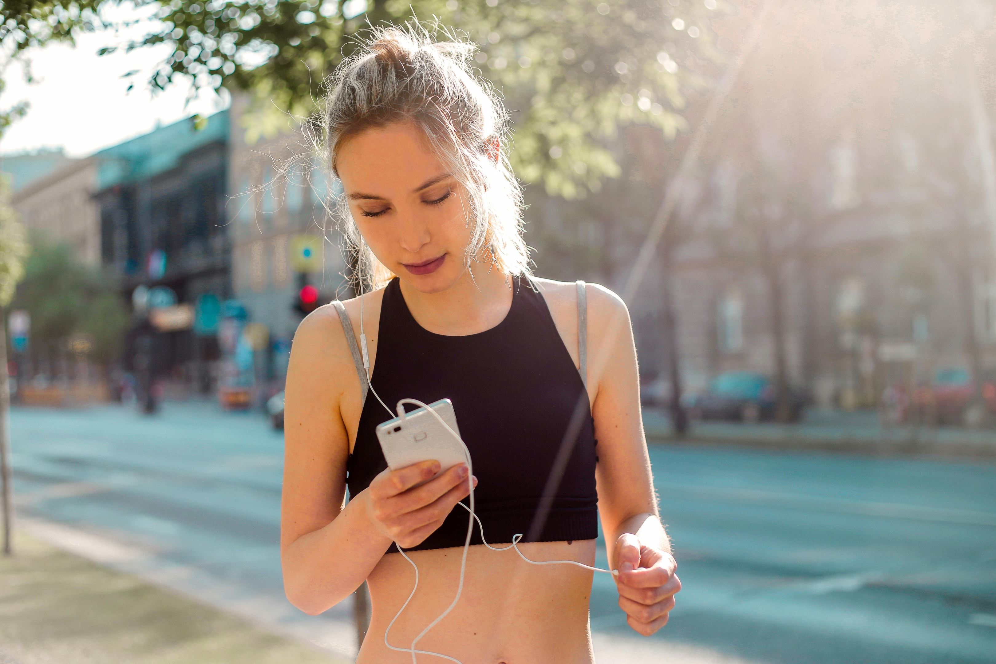 No matter what others say, you can't just squeeze in your lat pulldowns in between meetings. The gains you want are earned with focused, dedicated effort. Photo by Andrea Piacquadio: https://www.pexels.com/photo/woman-in-black-tank-top-holding-white-smartphone-3768598/