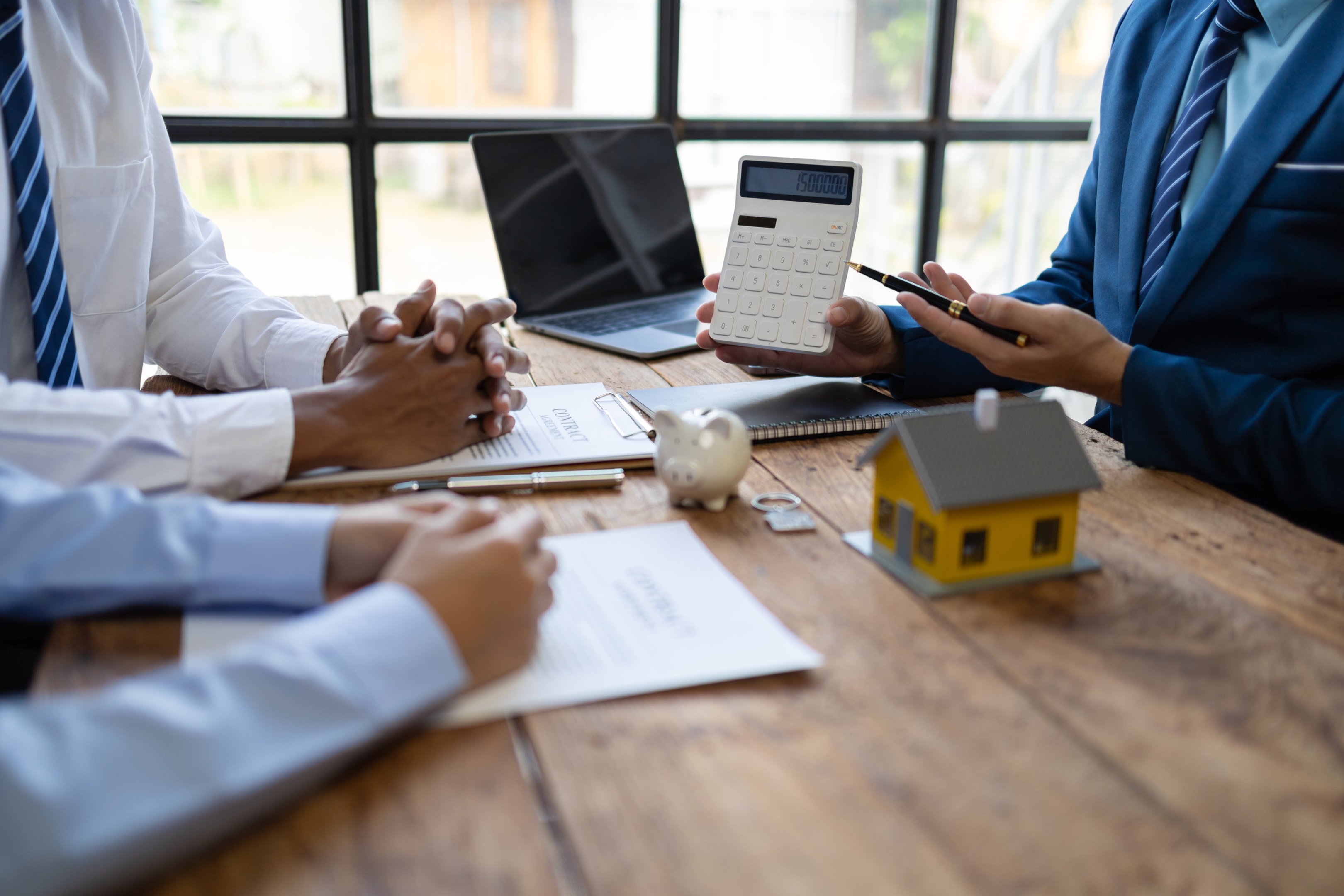 Property management discussion showing rental documents, calculator, and house model during the property management process
