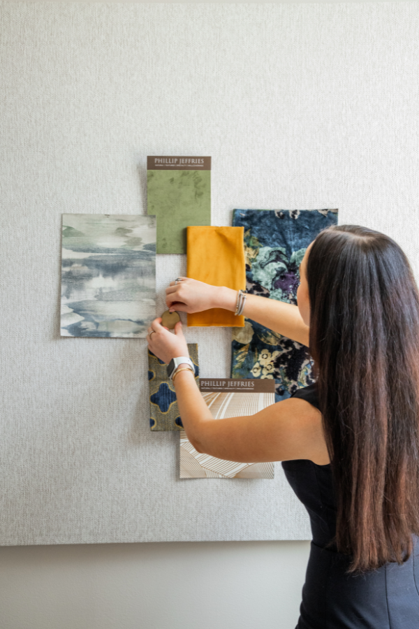 interior designer pinning a mood board with fabric samples in an interior design firm
