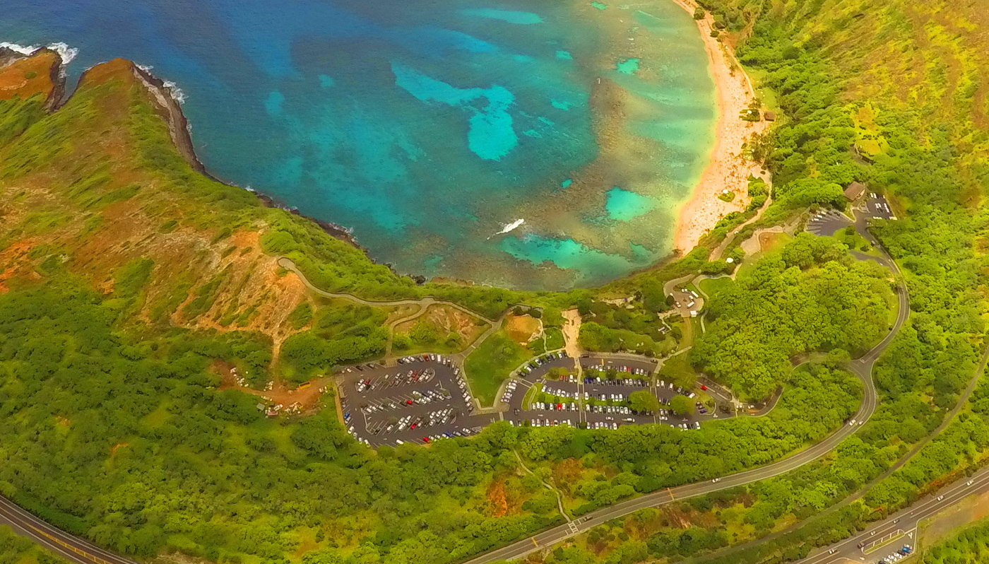 Aerial view of Hanauma Bay Nature Preserve with a parking lot in the foreground