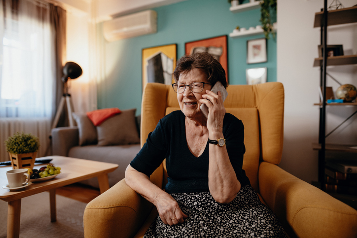 Older woman with dark hair talking on her cell phone. 