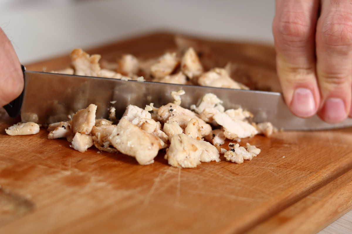 mincing chicken into tiny bite-sized pieces