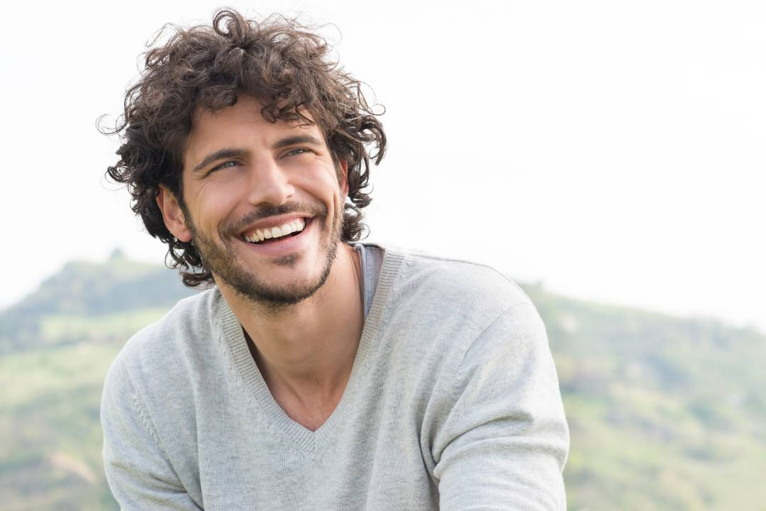 man with long hair smiling thinking about slow blood clotting, intravenous nac and anti inflammatory effects