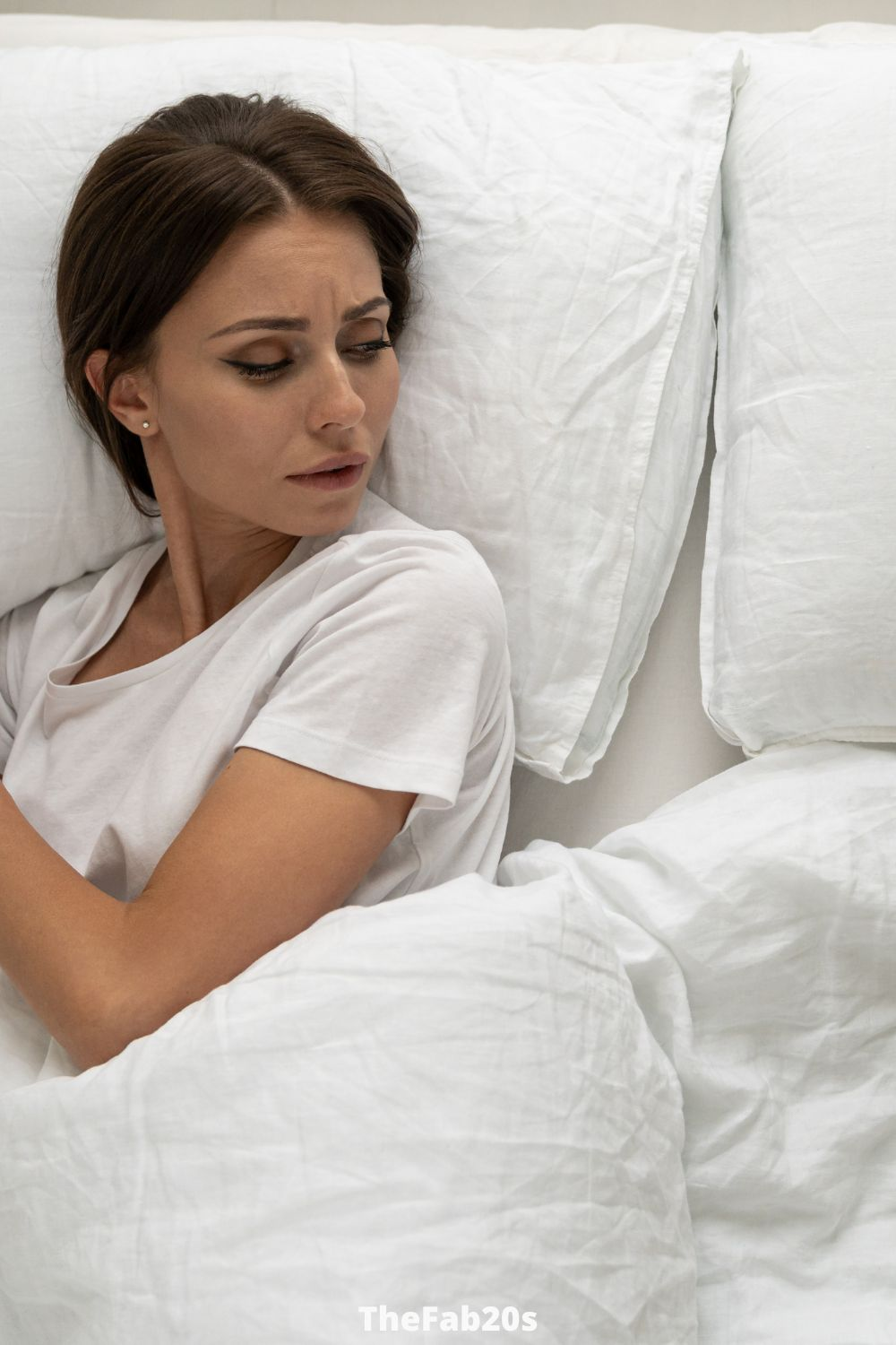 Woman alone in bed, looking to the empty pillow next to her - Featured in Signs He Only Wants You For Your Body