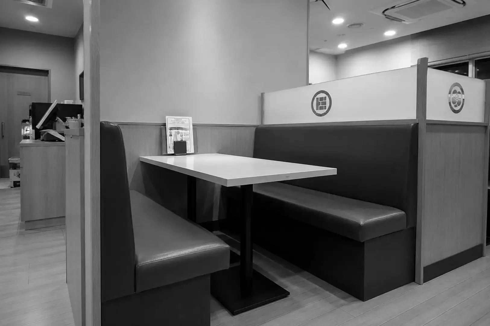 Cozy restaurant booth with cushioned seating and a minimalist dining table.