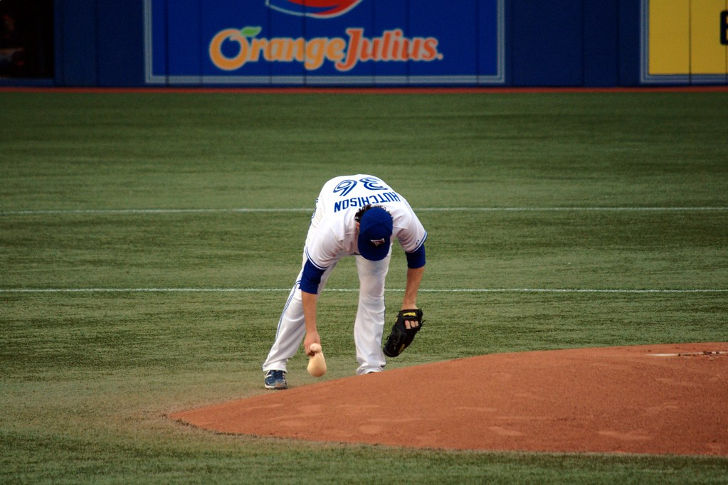 A baseball pitcher holding a rosin bag on the pitcher's mound