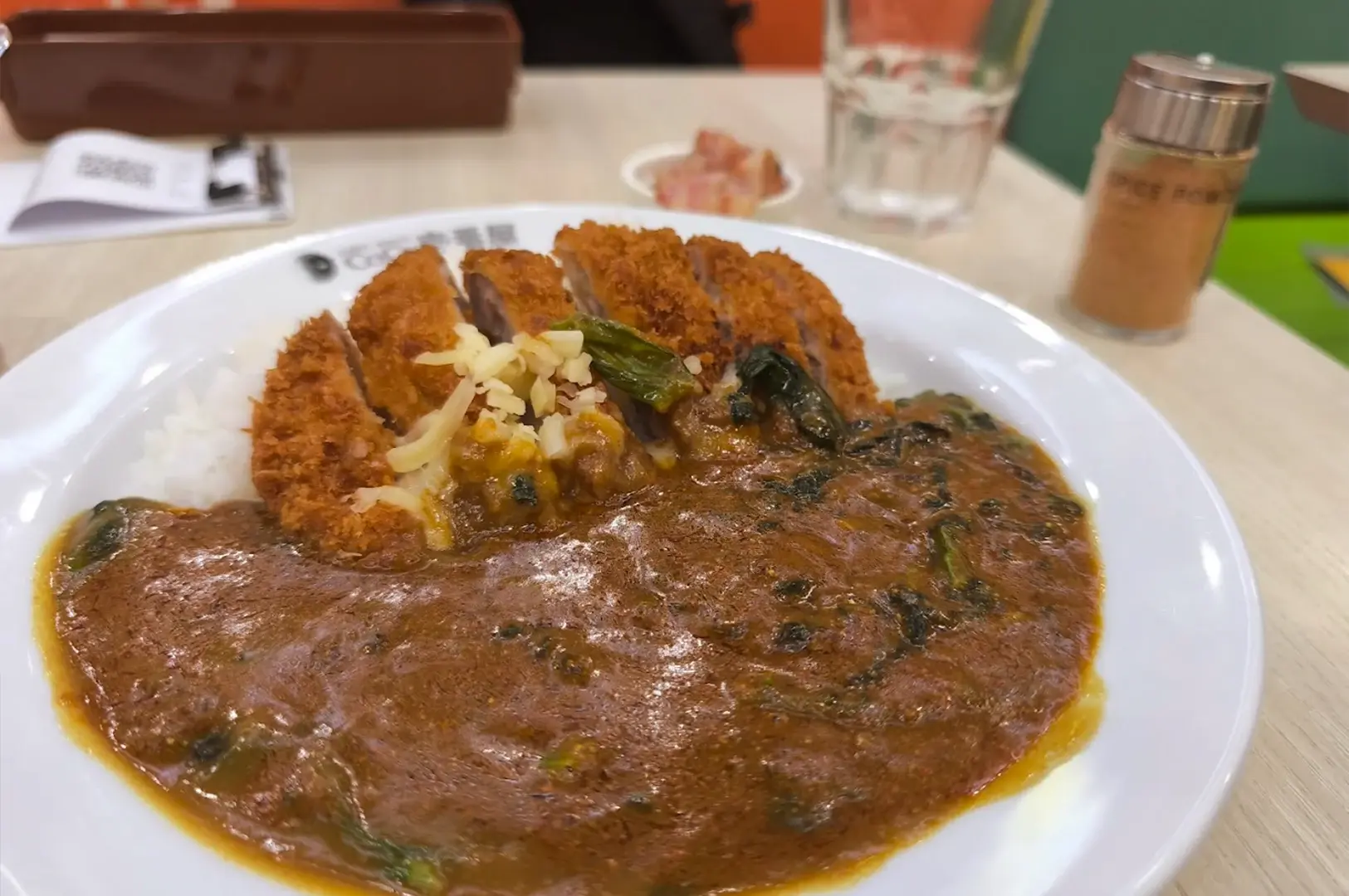 A signature Japanese pork katsu curry dish with a rich, spiced curry sauce and melted cheese at Coco Ichibanya, Singapore.
